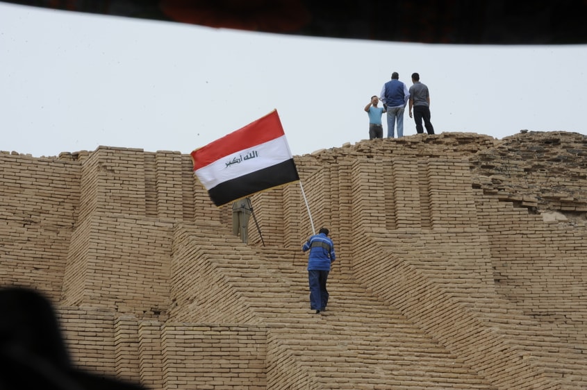 Iraqi flag being carried up the stairs at the ancient site of Ur.
